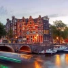 Online Amsterdamse grachtenpanden met boten op de voorgrond fotobehang Steden | Architectuur