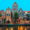 Clearance Amsterdamse grachtenpanden in de avond fotobehang Steden | Architectuur