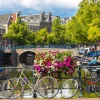 Online Fietsen op een Amsterdamse brug fotobehang Steden | Architectuur