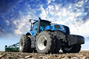 Outlet Grote blauwe tractor onder een bewolkte hemel fotobehang Tienerkamer | Kinderkamer