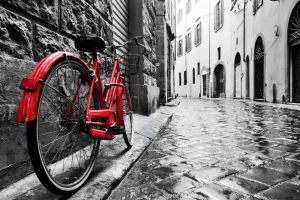 New Rode fiets in een zwart-witte straat fotobehang Transport | Architectuur