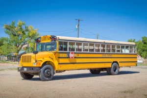 Best Traditionele gele schoolbus op een parkeerterrein fotobehang Kinderkamer | Transport
